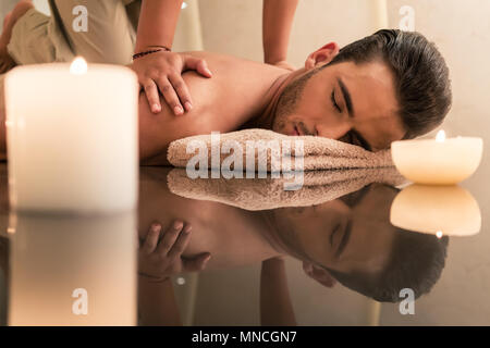 Jeune homme appréciant les avantages de guérison massage traditionnel thaïlandais Banque D'Images