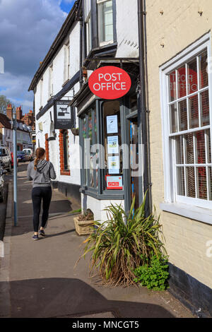 La jolie rue dans Charing, Kent. Cottages attrayants, boutiques, bureau de poste, cafés, au Royaume-Uni. Une jeune femme quitte le bureau de poste. Banque D'Images