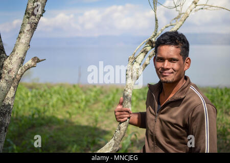 Sumatra, Indonésie - 15 janvier 2018 : agriculteur se trouve à côté de sa gousse arbre en île Samosir, Lac Toba, Sumatra, Indonésie Banque D'Images