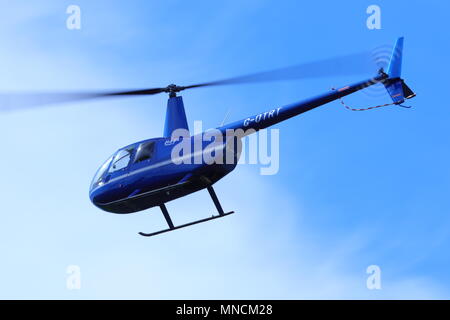 Un hélicoptère Robinson R44 G-OTRT survolant l'aéroport international de Leeds Bradford Banque D'Images