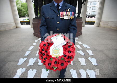 Le Flight Lieutenant Peintre Nigel est titulaire d'une couronne de fleurs comme il se tient parmi les 53 paires de gants de vol au Monument commémoratif du Bomber Command dans le Green Park Londonnien qui représentent les hommes qui sont morts dans le raid Dambusters en 1943, partie d'une série d'événements spéciaux marquant 75 ans depuis qu'un groupe d'aviateurs courageux ont pris part à l'un des raids les plus audacieux de la Seconde Guerre mondiale. Banque D'Images