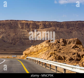 Route asphaltée en désert Néguev, Israël, route 40, l'infrastructure des transports en désert, montagnes pittoresques à vélo en Mizpe Ramon canyon en Israël Banque D'Images