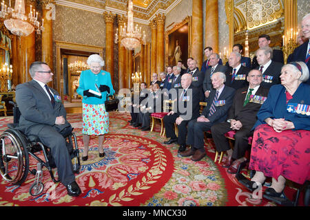 La reine Elizabeth II est donné un livre par le Major Peter Norton GC (à gauche), qui rappelle les exploits accomplis par les vingt-cinq récipiendaires de la Croix de Victoria et George médailles, à la suite d'une photo de groupe prise au palais de Buckingham à Londres. Banque D'Images