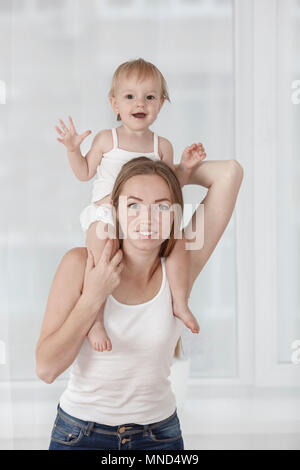 Portrait de fille heureuse mère portant sur les épaules à la maison Banque D'Images