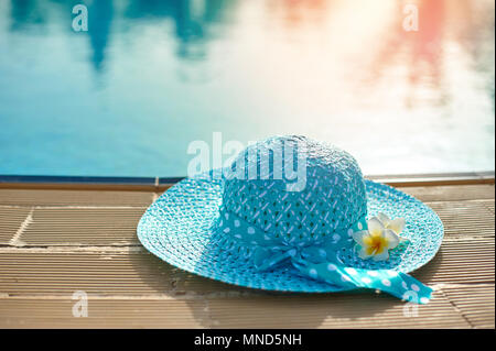 Beach hat à côté de la piscine d'été au coucher du soleil avec l'espace pour votre texte Banque D'Images