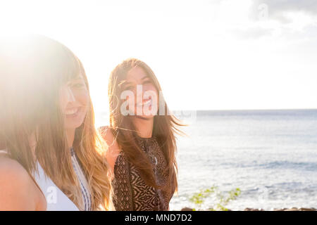 Trois jeunes femmes amis marcher ensemble sur un mur près de la plage à Ténérife. Profitez des locations sous un ciel bleu avec un soleil jaune. Mains en mains. Banque D'Images