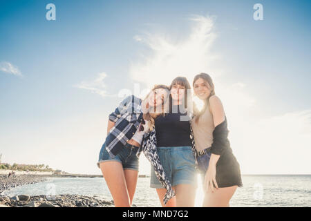 Groupe de trois jeune femme profitez de l'été sur une plage de roche à Tenerife, hug eux-mêmes avec beaucoup de rire et sourire pour une équipe parfaite Banque D'Images