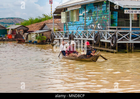 Une femme et deux jeunes garçons sont partis en canot dans un canot en bois sur la rivière de Siem Reap vers le village flottant de CHONG KNEAS et du lac Tonle Sap. Banque D'Images