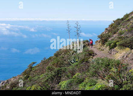 Un couple marche sur le sentier GR 131 à La Gomera dans les Canaries haut au-dessus de la Barranco de Erque et l'océan Atlantique près de Igualero Banque D'Images