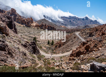 Un couple marche sur une piste de la caldera de Las Canadas du Teide sous le nuage nimbés bord du cratère dans la distance - Le Mont Teide Tenerife Banque D'Images