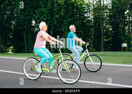 Caucasian couple riding bicycle Banque D'Images