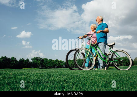 Couple avec leurs vélos dans le parc, vue latérale Banque D'Images