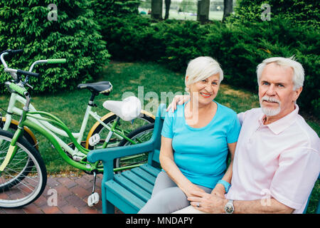 Portrait d'un couple de personnes âgées assis dans un parc de la ville Banque D'Images
