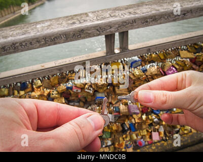 Paire de mains tenant les clés du cadenas sur le pont de l'amour à paris Banque D'Images