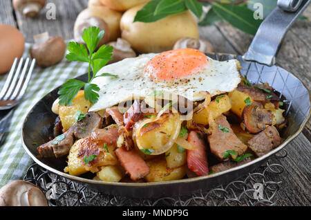 Pommes de terre sautées au boeuf et bacon, champignons, oignons une un œuf frit (soi-disant) groestl tyrolien, souvent servi dans une casserole Banque D'Images