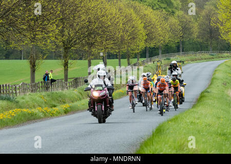 Tournage du film sur les vélos les cyclistes en pack, participant à des Tour de Yorkshire en 2018, course sur un paysage pittoresque lane - Ilkley, North Yorkshire, Angleterre, Royaume-Uni. Banque D'Images