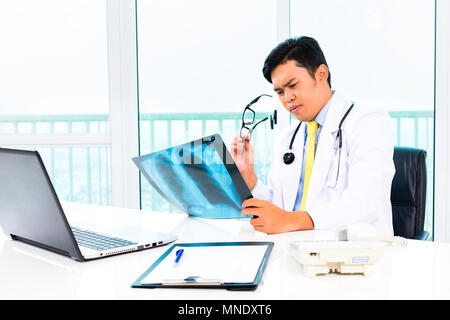 Asian doctor examining x-ray photo dans la pratique Banque D'Images