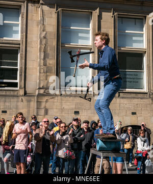 Royal Mile, Édimbourg, 16 Mai 2018. Les touristes profitent du soleil et des divertissements dans la rue sur le Royal Mile, Edimbourg, Ecosse, Royaume-Uni. Les touristes regardent un artiste de rue appelé Daniel, dont l'acte comprend jongler avec des torches flamboyantes et de grands couteaux et machettes Banque D'Images