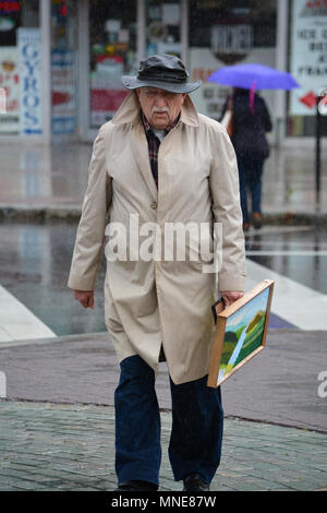 New York, USA. 16 mai 2018. Le jour avant les beaux-Arts Fiesta est prévu d'ouvrir en Wilkes Barre PA,83 ans,ancien artiste Frank Kluk slogs son chemin à travers la pluie torrentielle sur le chemin de la Wyoming Valley Art League tente.Le temps a été comme la mousson frappe N.E.PA.pour la semaine dernière, causant des inondations de petites criques.Exposants et artistes espèrent une rupture dans le modèle météorologique persistantes comme la date d'ouverture de la Fiesta en plein air est inférieure à 24 heures. voiture.Les Beaux-Arts Fiesta,une célébration de la scène et des arts visuels, est de 63 ans en 2018,le festival le plus établi. Banque D'Images