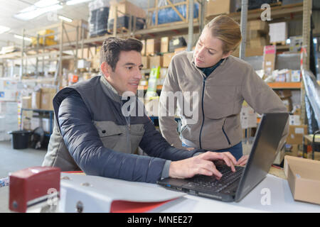 Deux gestionnaires working on laptop in warehouse Banque D'Images