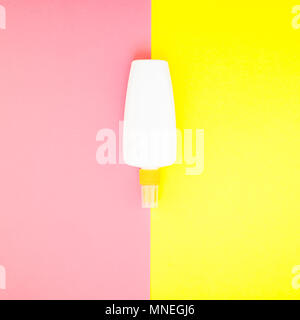 Bouteille vide de l'écran solaire sur maquette carré lumineux jaune et rose papier duotone arrière-plan. Les vacances d''une télévision créative concept laïcs texte modèle pour Banque D'Images