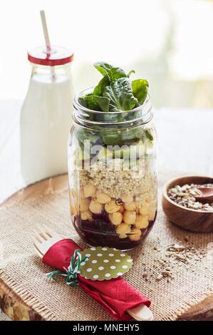 Salade de quinoa en couches Vegan, des pois chiches et de l'avocat dans un bocal en verre Banque D'Images