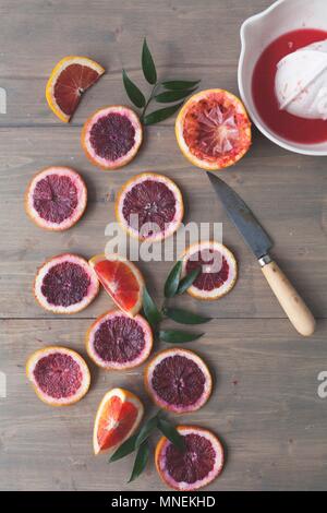 Les tranches d'orange sanguine avec un presse-agrumes Banque D'Images
