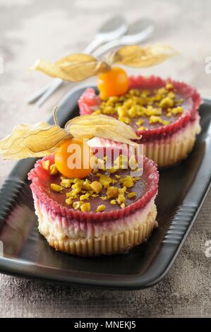 Mini gâteaux aux fruits rouges, physalis et pistaches Banque D'Images