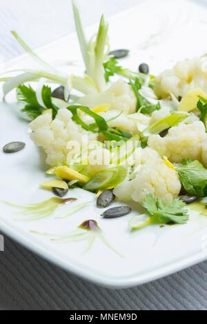 Salade de chou-fleur avec gingembre frais, graines de courge, oignons de printemps et de l'huile de graines de citrouille Banque D'Images