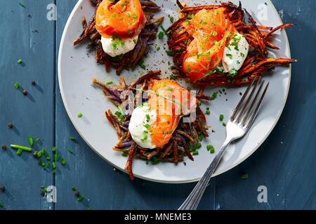 Rösti Vitelotte poêlée de pommes de terre suisse (gâteaux) avec la crème fraîche et le saumon Banque D'Images