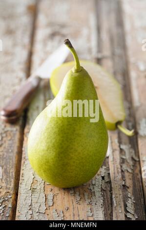 Toute une moitié de poire et une poire sur une surface en bois Banque D'Images