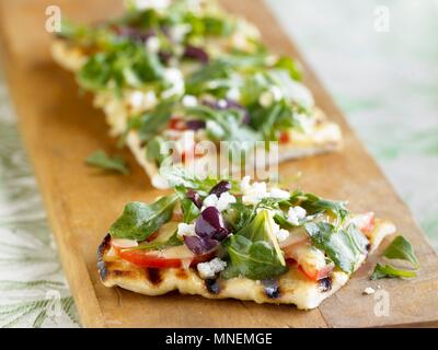 Pain Focaccia grillées garnies de tomates, roquette et fromage Queso émietté Banque D'Images