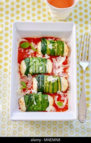 Rouleaux de courgettes avec du fromage frais garniture sur la sauce tomate Banque D'Images