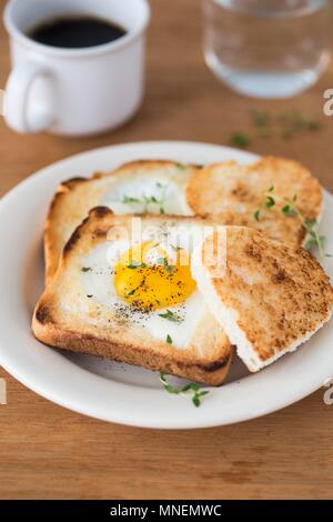 Un oeuf au plat en forme de cœur dans une tranche d'un pain grillé Banque D'Images