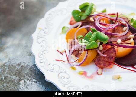 Salade d'orange sanguine avec oignons rouges et les noix de pin Banque D'Images