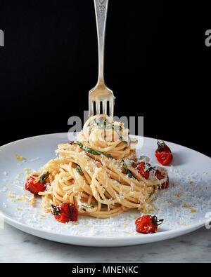 Spaghetti al limone avec tomates cerises boursouflée Banque D'Images