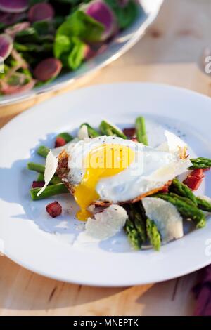 Œuf frit sur les asperges vertes avec lardons et parmesan Banque D'Images