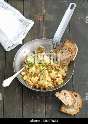 Oeufs brouillés avec chanterelles servi avec du pain Banque D'Images