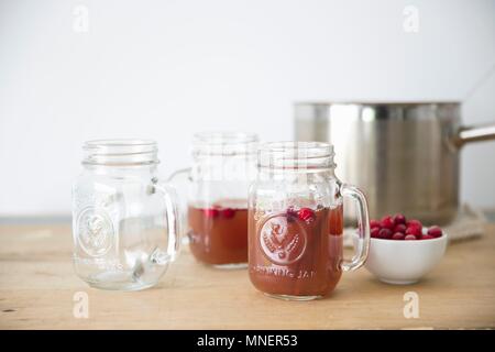 Cidre de pomme chaud aux canneberges dans des tasses en verre Banque D'Images