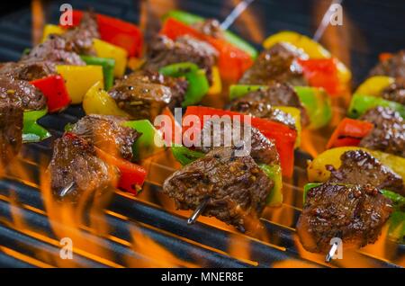 Brochettes de boeuf aux poivrons sur un barbecue en flammes Banque D'Images