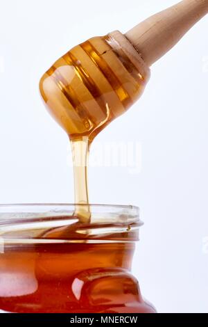 Dégoulinant de miel dans un verre Banque D'Images