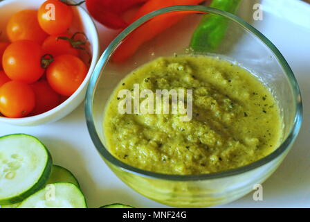 Poivre concombre potage dans un plat en verre clair avec des tomates et concombres sur le côté, gros plan. Banque D'Images