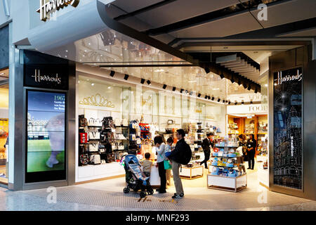 Une famille asiatique shopping à Harrod's duty free shop à Londres Heathrow Airport Terminal 2 Banque D'Images