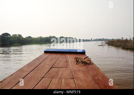 Une barge fluviale se glisse dans l'eau sur la rivière Tonle Sap, au Cambodge. Matin tranquille sur la scène des plaines d'inondation dans le bassin inférieur du Mékong Banque D'Images