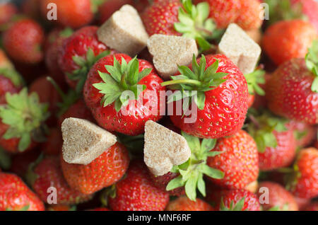 Petits fruits mûrs juteux fraise rouge avec des morceaux de sucre à la cannelle en forme de coeur Banque D'Images
