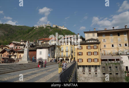 VARALLO SESIA, ITALIE - 25 avril 2018 : Les personnes qui traversent le pont sur la rivière Mastellone avec une vue sur les maisons typiques dans l'arrière-plan Banque D'Images