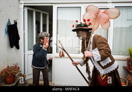 Au solstice d'hiver festivités à Vila Cha de Braciosa, le caractère Velha (la vieille femme) porte un bâton avec plusieurs vessies de porc et vole Banque D'Images