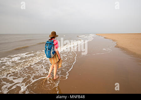 Womasn la marche dans les eaux peu profondes au point d'Ayr, Flintshire, Pays de Galles, Royaume-Uni, le point le plus au nord du Pays de Galles Banque D'Images