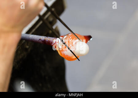 Artiste de verre dans un verre fabrication travaille sur seagull sculpture faite de verre chaud. Se concentrer sur les mains et la figure seagull. Close up shot Banque D'Images