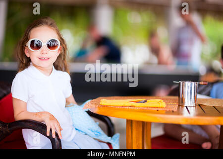 Adorable petite fille dans le café en plein air journée d'été Banque D'Images